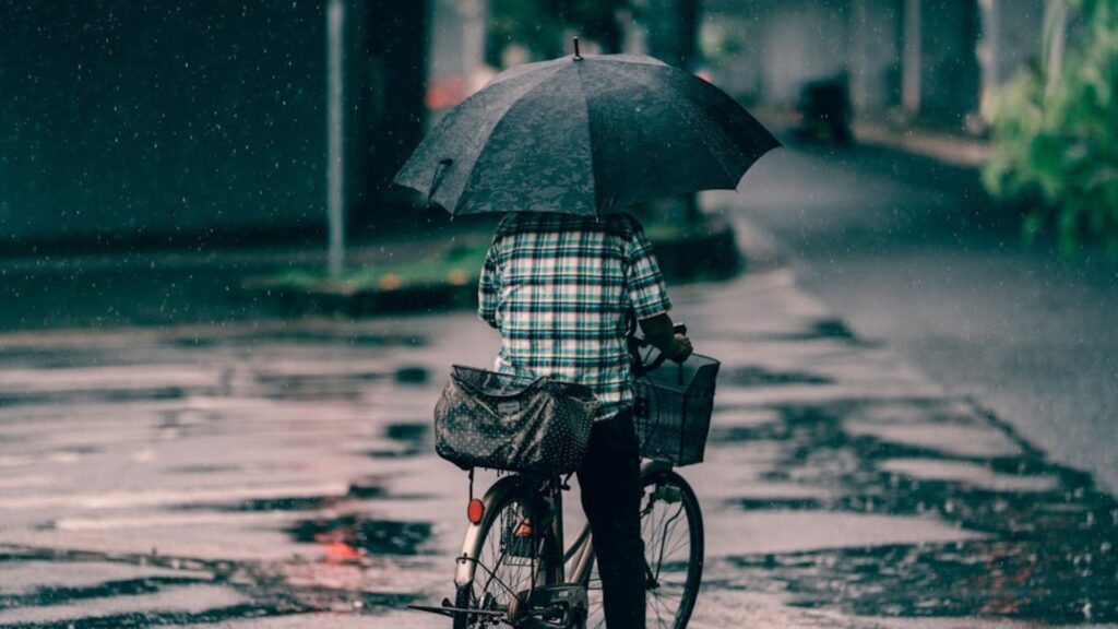 Personne à vélo sous un parapluie